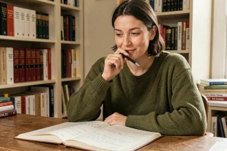 Femme étudiant la grammaire française avec un carnet de notes ouvert, illustrant la règle d'orthographe entre appelle-moi et appelles-moi