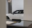 a white car is parked in a showroom