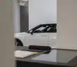a white car is parked in a showroom