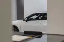 a white car is parked in a showroom