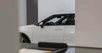 a white car is parked in a showroom