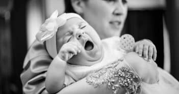 Comment faire dormir un bébé dans son lit ? man in gray shirt carrying baby in grayscale photography